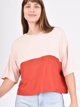 Remera manga corta con diseño color block, parte superior color beige y parte inferior color negro.