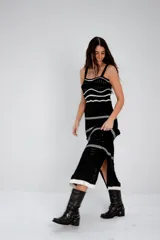 Vestido midi negro de tejido de punto calado con rayas horizontales blancas, breteles finos y abertura lateral.
