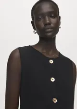 Chaleco negro de tejido de punto fino, con cuello caja, diseño recto y cierre frontal de botones dorados.