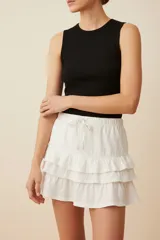 Minifalda blanca de algodón con cintura elastizada y tres volados.