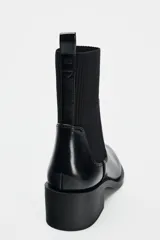 Botín Chelsea negro de charol con caña de tejido elástico acanalado y tacón ancho.