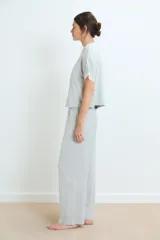 Conjunto de pijama negro, compuesto por una remera de manga corta con detalle de encaje en los puños y un pantalón largo de corte recto.