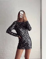 Minivestido negro con lentejuelas y estampado geométrico blanco.