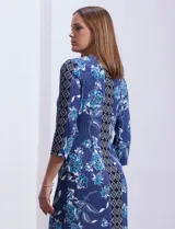 Vestido corto azul con estampado floral y geométrico, cuello redondo con abertura y aplique metálico, y mangas 3/4.