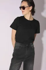 Pantalón de jean gris oscuro con lavado gastado, corte acampanado y tachas plateadas en los laterales.