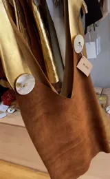 Chaleco de cuero gamuza en color óxido con detalles en cuero dorado y apliques de nácar.