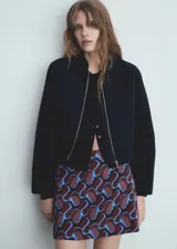 Chaqueta bomber azul marino con cierre delantero con cremallera y cuello redondo.