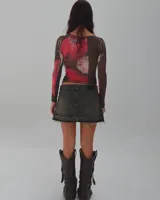 Minifalda de jean gris oscuro con efecto lavado, tiro bajo y ruedo desflecado.