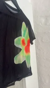 Top negro de microtul con estampado de flores rojas y verdes.