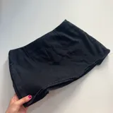 Mini cinto de denim blanco con detalles deshilachados y cierre de botón.