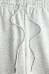 Pantalón de jogging gris melange, de corte holgado, con cintura elástica ajustable con cordón y puños elásticos.
