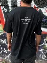 Remera negra oversize con cuello redondo y estampado pequeño en el pecho.