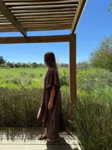 Vestido largo color beige, de corte amplio, con mangas cortas abullonadas y volado en el ruedo.