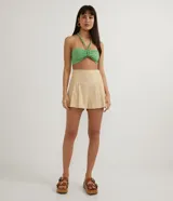 Short color beige de lino con cintura alta, cintura ancha con líneas multicolores, cierre lateral con cremallera y pliegues.