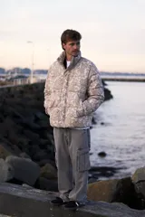 Campera puffer de corderoy con estampado paisley en tonos beige y cuello alto.