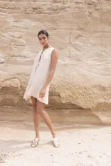 Vestido corto color beige, sin mangas y con cuello redondo.