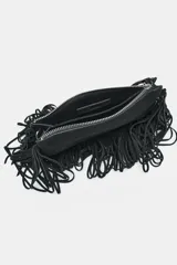 Bolso mini bandolera de serraje negro con flecos en el cuerpo, asa de hombro y bandolera extraíbles, doble bolsillo interior y cierre con cremallera.
