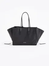 Bolso tote pequeño de cuero vacuno negro, con cierres funcionales en los laterales para mayor apertura y espacio. Incluye bolsillo cruzado interno y tag con aplique metálico.