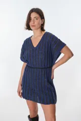 Vestido corto de tejido de punto con cuello V y mangas cortas, con diseño de rayas verticales en tonos azul oscuro y negro, con hilos de lurex que le dan brillo. Se ajusta a la cintura con un lazo fino negro.