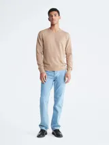 Sweater de lana merino color beige, con cuello redondo y logo bordado en el pecho.