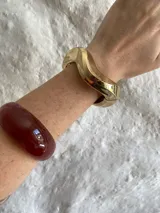 Brazalete dorado con forma irregular, elaborado en material metálico.
