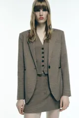 Blazer de cuello solapa y manga larga con estampado de pata de gallo en tonos marrones y negros. Bolsillos de vivo en delantero, detalle de coderas a contraste y cierre frontal con botón.