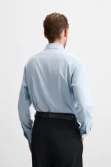 Camisa blanca de corte regular, cuello italiano, manga larga con puños abotonados y cierre frontal con botones.