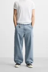 Pantalón de jean negro, corte relaxed fit, con bolsillos frontales y traseros tipo parche, tira multifunción y bolsillo tipo parche en las piernas. Tiene efecto lavado y cierre frontal con cremallera y botón.