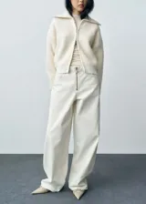Pantalón de jean blanco de corte wide leg con tiro medio y cierre frontal con cremallera.