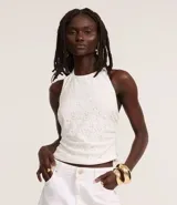 Blusa blanca de encaje con escote halter y espalda descubierta.