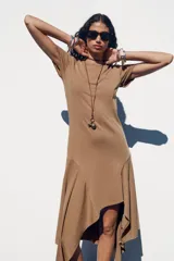 Vestido largo color marrón claro, de corte recto, con cuello redondo, mangas cortas y bajo asimétrico con volados.