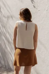 Blusa sin mangas color crema, de corte holgado y confeccionada en lino y algodón.