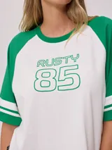 Remera bicolor Rusty con cuerpo verde lima y mangas ranglán grises con dos rayas blancas en los puños. Estampado frontal con el logo de la marca y el número 85.
