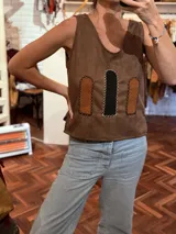 Chaleco marrón de tela agamuzada con apliques cortados y bordados a mano.