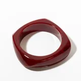 Brazalete rígida de resina color borgoña con forma cuadrada.