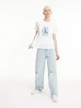 Remera blanca de algodón orgánico con corte regular, cuello redondo y mangas cortas. Estampado fotográfico con el logo de Calvin Klein Jeans en el pecho y dirección de la marca en la manga.
