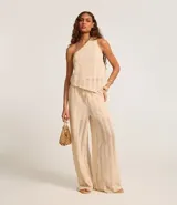 Pantalón recto color beige con textura, confeccionado en algodón BCI más sostenible, con cintura alta elástica y lazo de ajuste.