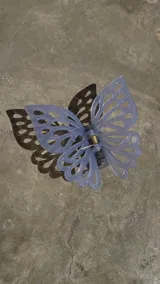 Broche para el pelo con forma de mariposa color lila, con diseño calado en las alas y agarre tipo pinza.