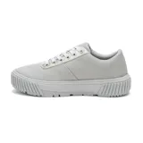 Zapatillas urbanas CAT modelo AMP, color gris claro, con detalles plateados en la lengüeta y contorno de los cordones. Capellada de canvas recubierta en PU, forro de malla interior reciclada, plantilla de espuma EVA, suela de goma duradera y con gran tracción.
