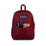 Mochila JanSport color borgoña con logo en etiqueta azul. Tiene un compartimento principal, bolsillo frontal con cremallera, bolsillo lateral para botella de agua, tirantes acolchados y panel trasero acolchado.