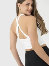 Top deportivo blanco con espalda descubierta y tiras cruzadas en el frente.