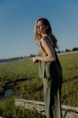 Conjunto de top y pantalón color beige. El top es de breteles anchos, con detalle en dos colores y un bordado en su delantera. El pantalón es liso, de corte recto ancho con bolsillos a los costados y cintura con botones y elástico.
