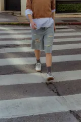 Zapatillas urbanas de cuero color crema con puntera y talón en gamuza gris, suela de goma marrón y cordones grises.