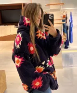 Saco de lana marrón con diseño geométrico multicolor, cuello con solapa, cierre frontal con botones y bolsillos delanteros.