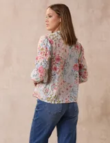 Blusa de gasa plisada estampada con flores azules, marca Floral & Ivy. Cuello a la base, escote en V y lazo de ajuste.