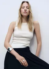 Musculosa blanca de tejido de punto fino, sin mangas y cuello redondo. Diseño entallado.