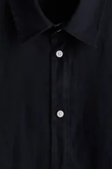 Camisa de hombre de lino color azul marino, de corte regular, con cuello inglés, tapeta clásica, mangas largas con puños abotonados y bajo redondeado.