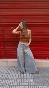 Pantalón de jean celeste de tiro medio con pierna extra ancha y caída fluida, con bolsillos delanteros y traseros, y cierre frontal con cremallera y botón metálico.