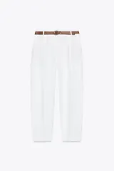 Pantalón blanco de lino, de tiro alto con pinzas delanteras, bolsillos frontales y falsos bolsillos con solapa en la espalda. Incluye cinturón marrón.