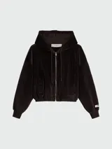 Buzo con capucha y cierre frontal de color negro, confeccionado en tejido de terciopelo o pana fina. Presenta un corte cropped y holgado, con puños y cintura elásticos. Tiene bolsillos tipo canguro y una etiqueta con el logo de la marca en la parte interior del cuello.